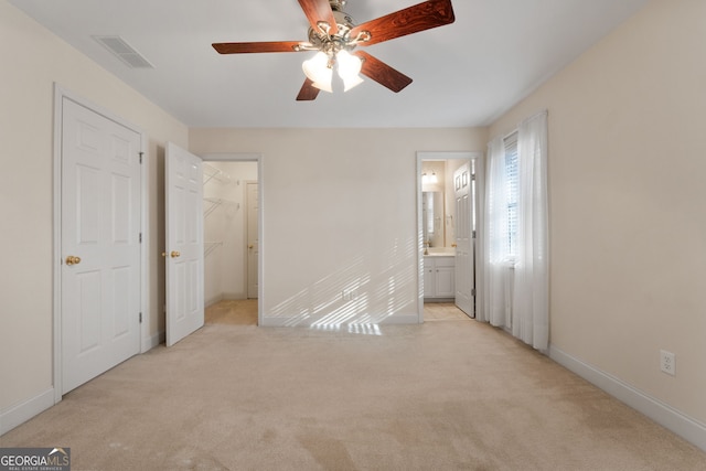 unfurnished bedroom featuring light carpet, baseboards, visible vents, and connected bathroom