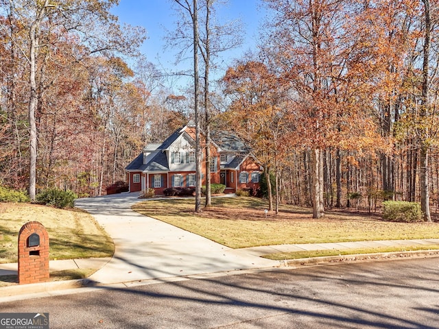 view of front facade with concrete driveway and a front yard