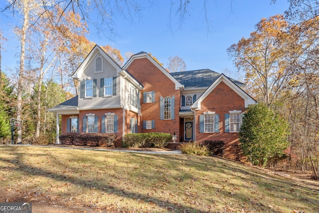 view of front facade with a front lawn and brick siding