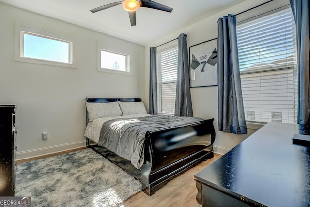 bedroom featuring light wood finished floors, ceiling fan, and baseboards