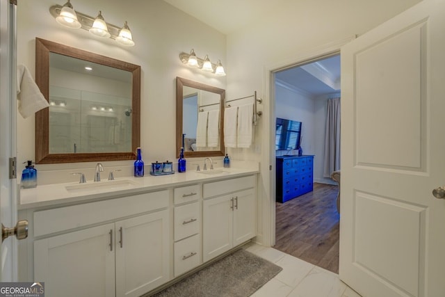 full bathroom with a stall shower, marble finish floor, a sink, and double vanity