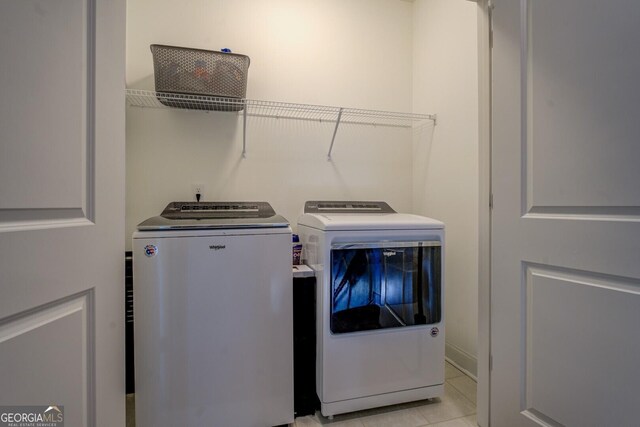 laundry area featuring laundry area, light tile patterned flooring, and washer and clothes dryer