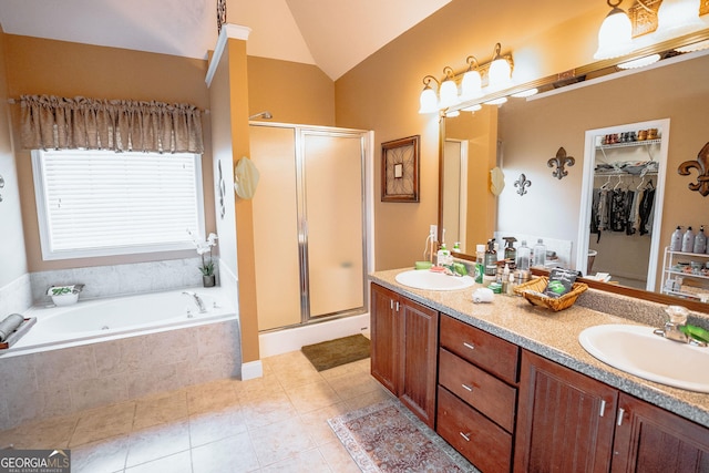 bathroom featuring double vanity, a stall shower, vaulted ceiling, and a sink