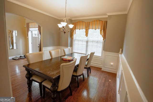 dining space featuring a chandelier, arched walkways, crown molding, and dark wood finished floors