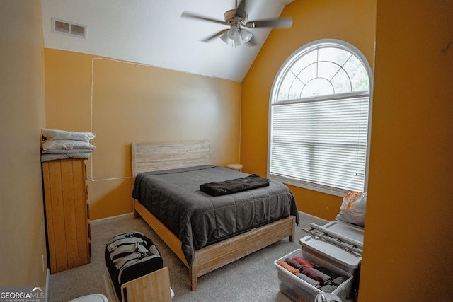 carpeted bedroom with visible vents, vaulted ceiling, and a ceiling fan