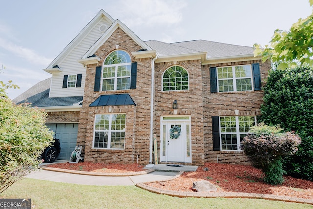 view of front facade featuring a garage, brick siding, and a shingled roof