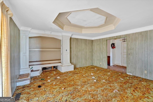 interior space with decorative columns, a tray ceiling, and crown molding