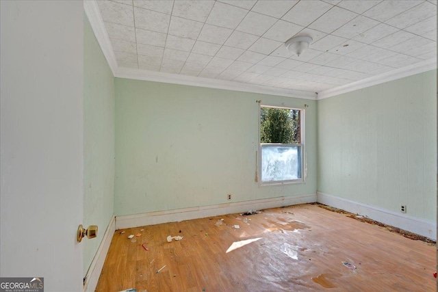 unfurnished room featuring baseboards, ornamental molding, and wood finished floors