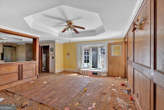 interior space with a tray ceiling, gas water heater, a ceiling fan, and crown molding