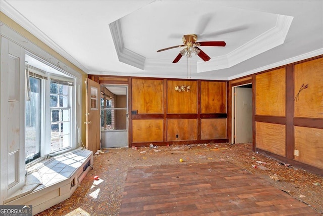 interior space featuring a tray ceiling, a ceiling fan, and ornamental molding