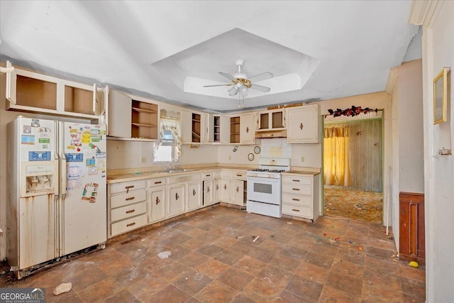 kitchen featuring white appliances, ceiling fan, a tray ceiling, open shelves, and a sink