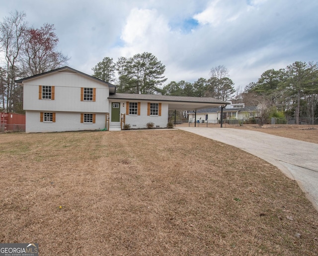 split level home with an attached carport, brick siding, fence, driveway, and a front yard