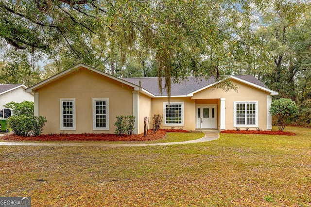 ranch-style house featuring stucco siding, roof with shingles, and a front yard