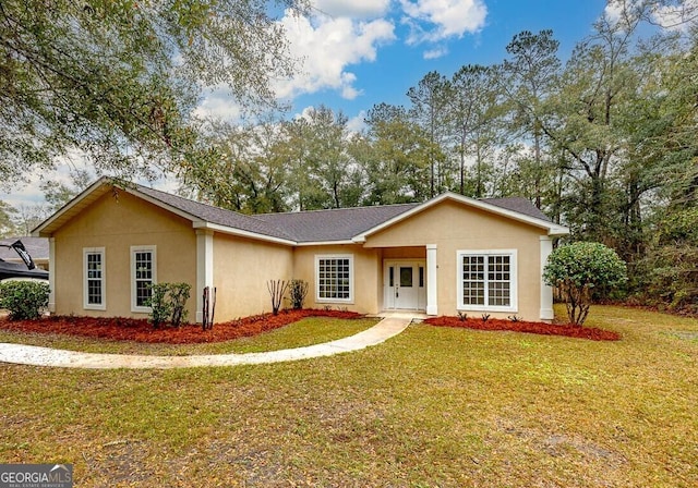 ranch-style home featuring a front lawn and stucco siding