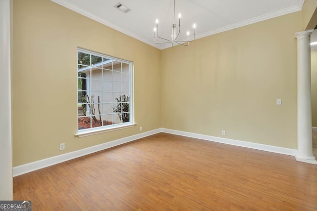 spare room with visible vents, crown molding, baseboards, wood finished floors, and ornate columns