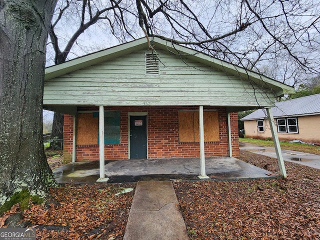 view of front of property featuring brick siding and a porch