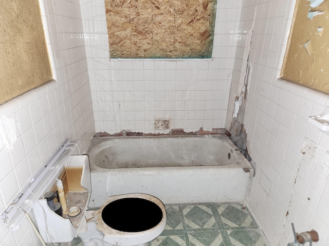 bathroom with tile walls and a bathtub