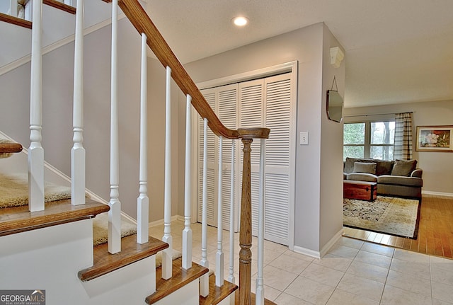 stairs with recessed lighting, baseboards, a textured ceiling, and tile patterned floors