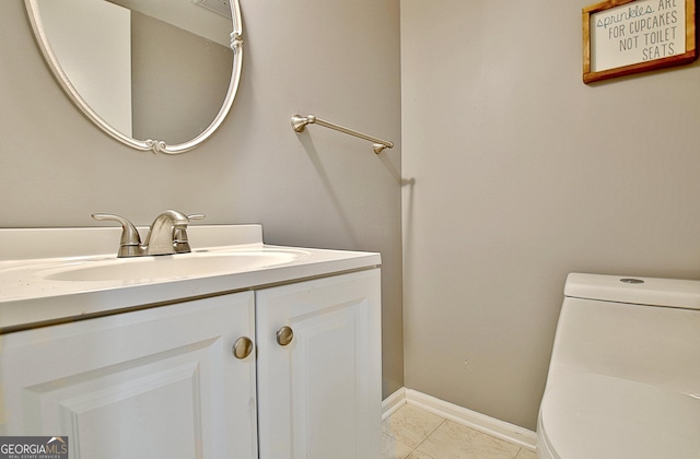 bathroom with toilet, tile patterned floors, baseboards, and vanity