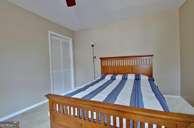 bedroom featuring a textured ceiling, ceiling fan, baseboards, a closet, and carpet