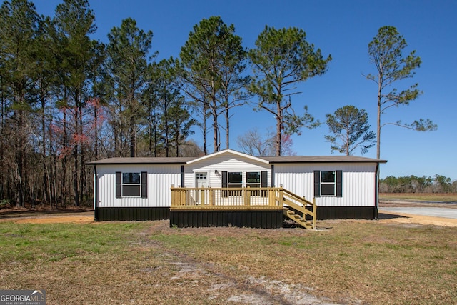 manufactured / mobile home featuring a deck and a front lawn