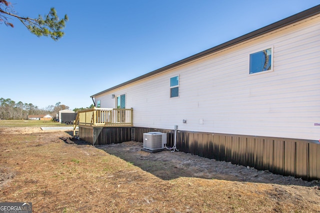 view of property exterior with central AC and a wooden deck