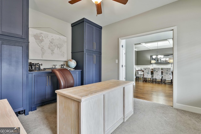 home office featuring baseboards, light colored carpet, and ceiling fan with notable chandelier