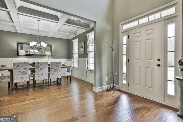 entryway with beamed ceiling, wood finished floors, visible vents, and coffered ceiling