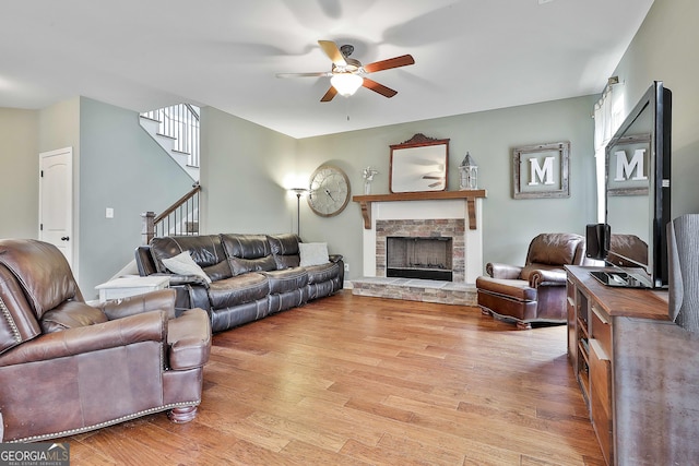 114 Austin Storey Cir, Newnan, GA 30263 - living room with ceiling fan, light wood-type flooring, stairway, and a stone fireplace
