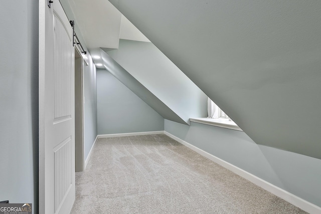 114 Austin Storey Cir, Newnan, GA 30263 - additional living space featuring a barn door, carpet, baseboards, and vaulted ceiling