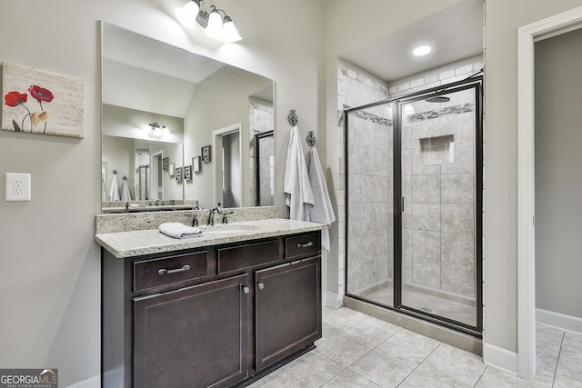 full bath featuring baseboards, vanity, a shower stall, and tile patterned flooring