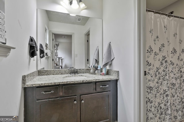 full bathroom with vanity, curtained shower, and visible vents