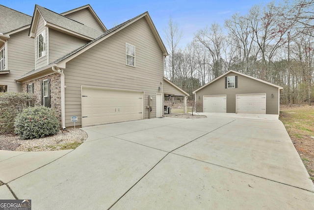 view of property exterior with a garage, roof with shingles, and an outdoor structure