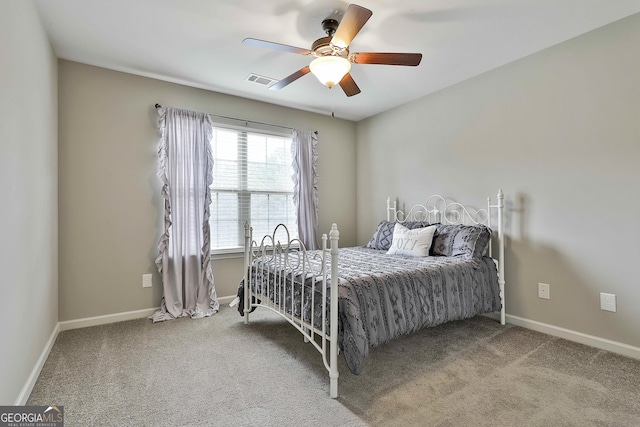 carpeted bedroom with visible vents, a ceiling fan, and baseboards