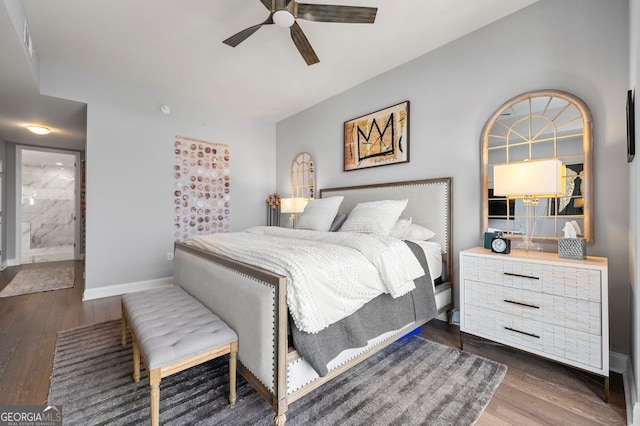 bedroom featuring a ceiling fan, connected bathroom, baseboards, and wood finished floors