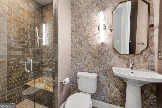 full bathroom with a stall shower, toilet, and wallpapered walls