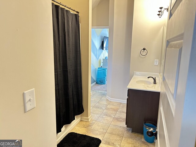 full bath with baseboards, a shower with shower curtain, and vanity
