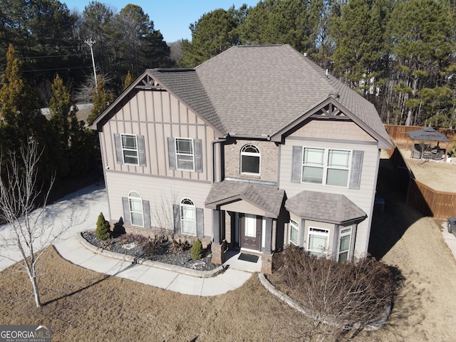 view of front of home featuring a shingled roof, fence, and board and batten siding