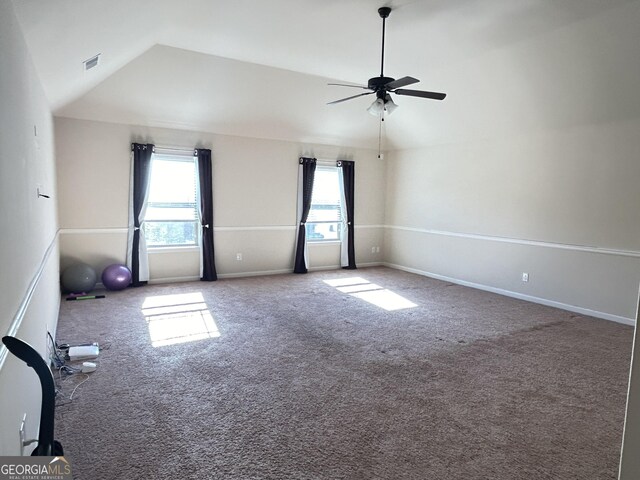carpeted empty room with a ceiling fan, baseboards, vaulted ceiling, and visible vents