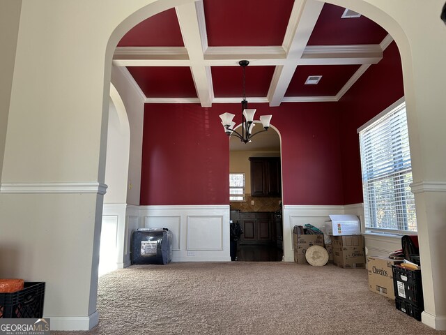 living area featuring carpet flooring, plenty of natural light, and beamed ceiling