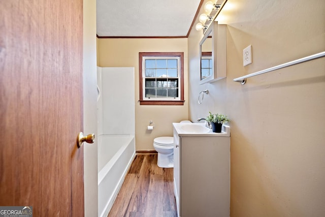 full bathroom featuring toilet, ornamental molding, vanity, wood finished floors, and baseboards