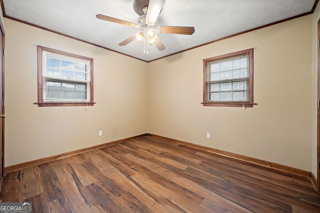 empty room featuring baseboards, ceiling fan, wood finished floors, and crown molding