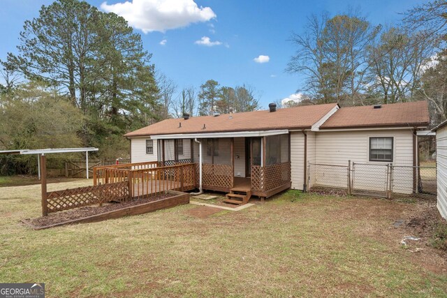 back of house with a gate, fence, a deck, and a lawn