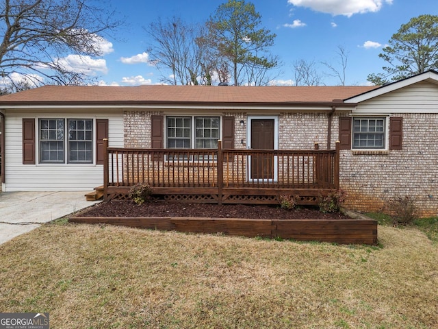 ranch-style house featuring brick siding, a wooden deck, and a front yard