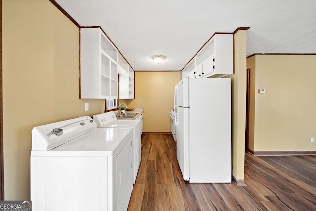 laundry area with crown molding, dark wood finished floors, washer and clothes dryer, a sink, and baseboards