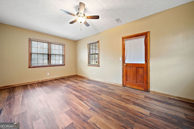 unfurnished room with a textured ceiling, ceiling fan, wood finished floors, and baseboards