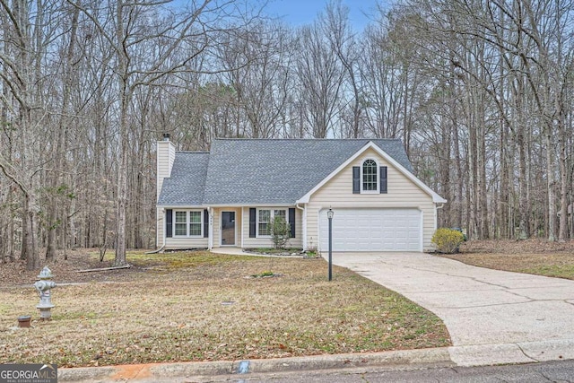 view of front of property featuring a garage, driveway, roof with shingles, a chimney, and a front yard