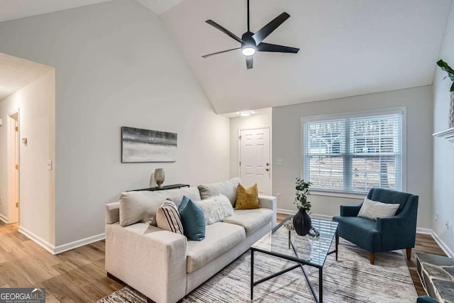 living room featuring a ceiling fan, light wood-type flooring, high vaulted ceiling, and baseboards