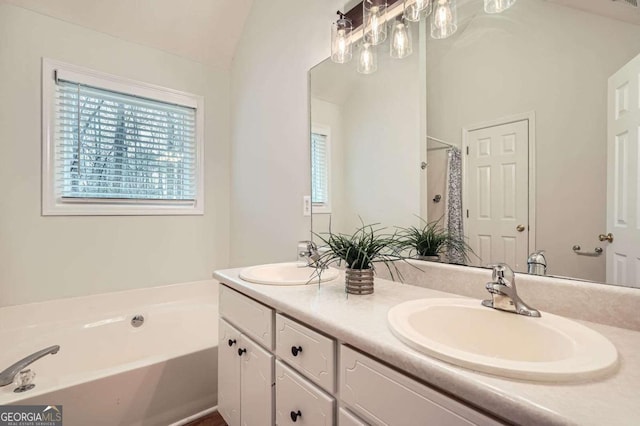 bathroom featuring a bath, double vanity, a sink, and lofted ceiling