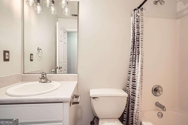 bathroom featuring shower / bath combo, vanity, and toilet